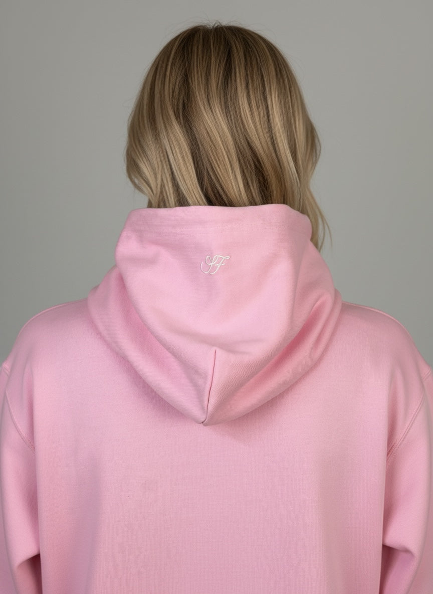 Model wearing the baby pink Saltus Fidei hoodie, alternate studio angle
