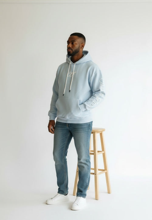 Model wearing the sky blue Saltus Fidei hoodie, studio shot