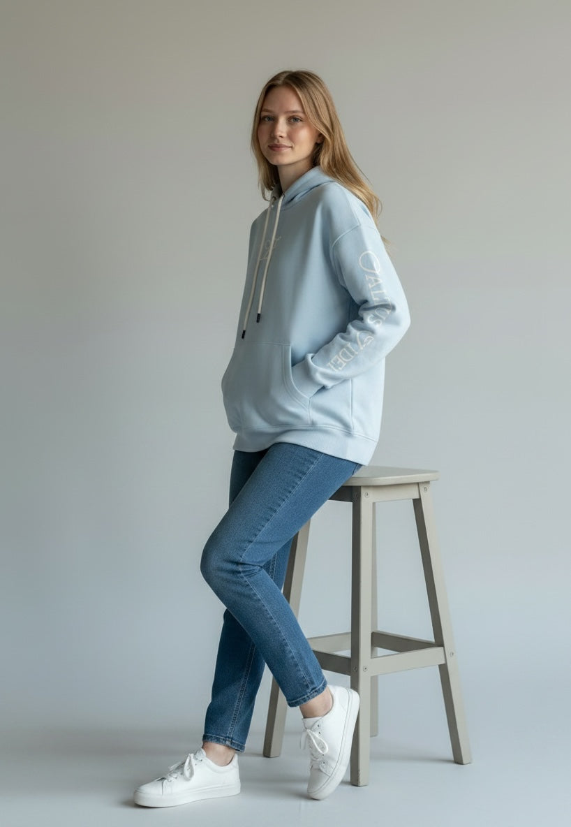 Model wearing the sky blue Saltus Fidei hoodie, alternate studio angle