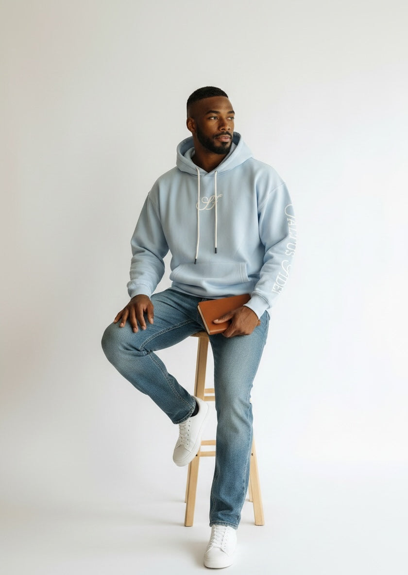 Model wearing the sky blue Saltus Fidei hoodie, alternate studio angle
